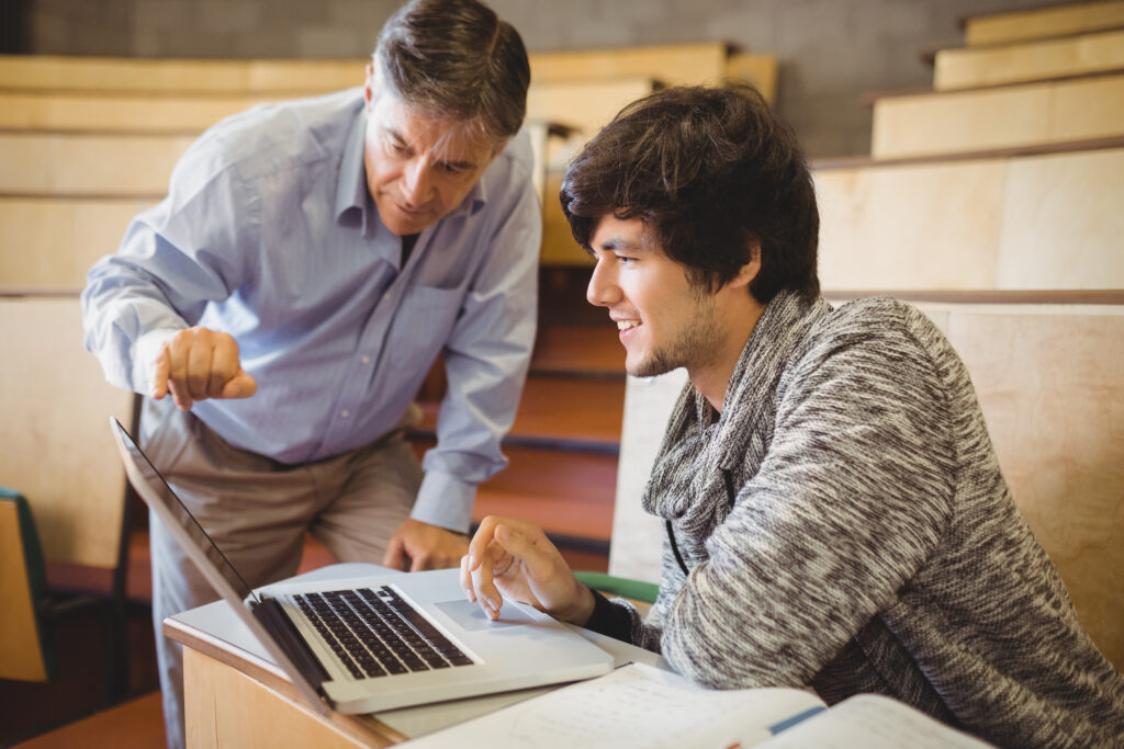 professor showing student something on a laptop